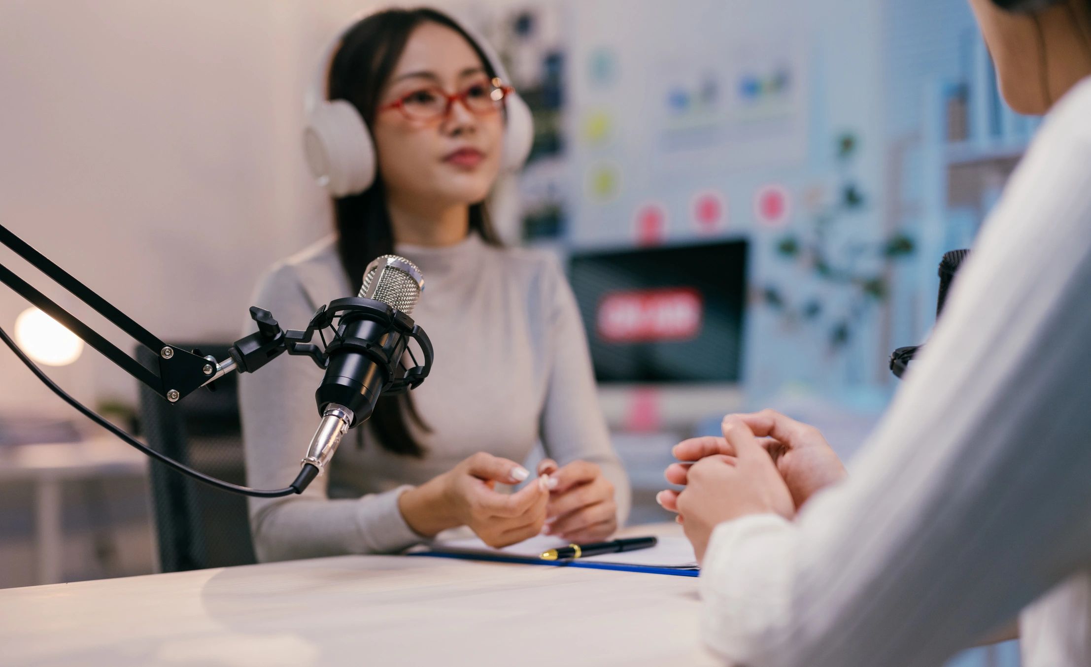 Two young female podcasters are recording a new episode.